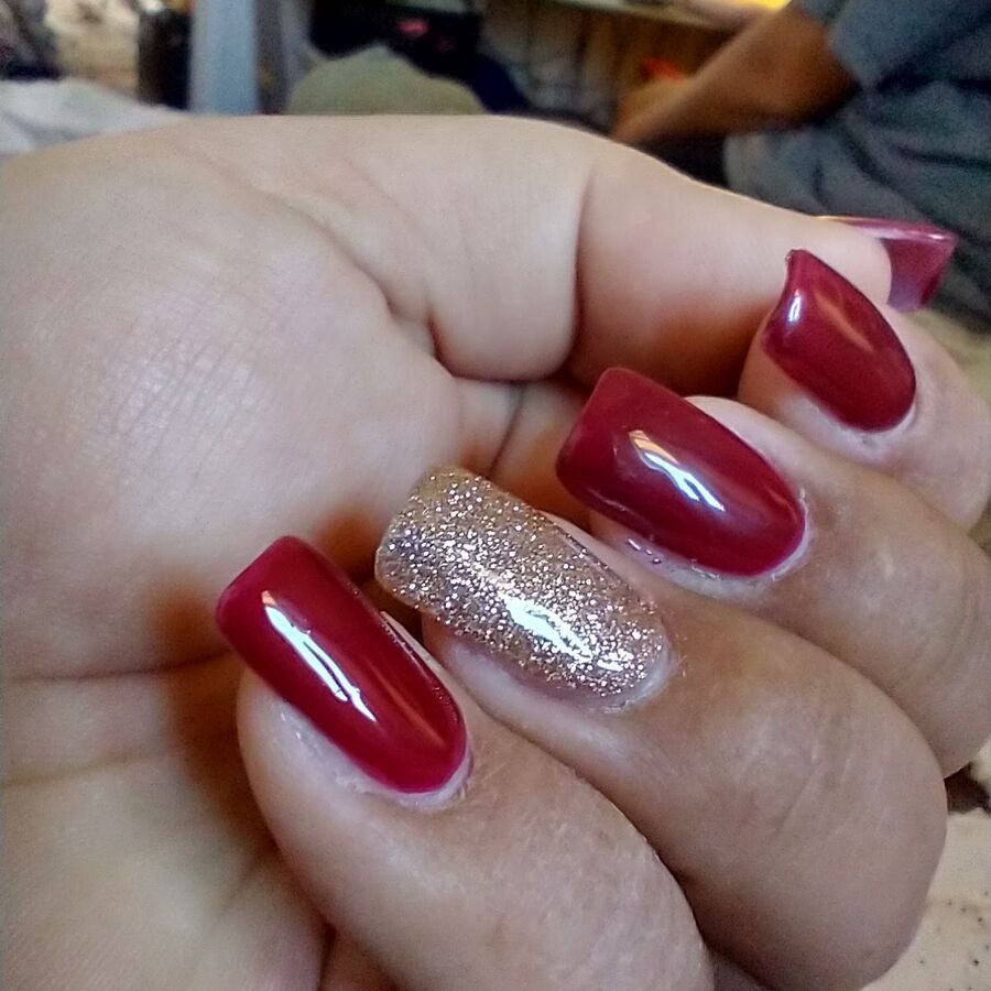 Deep red gel nails with a glitter accent finger